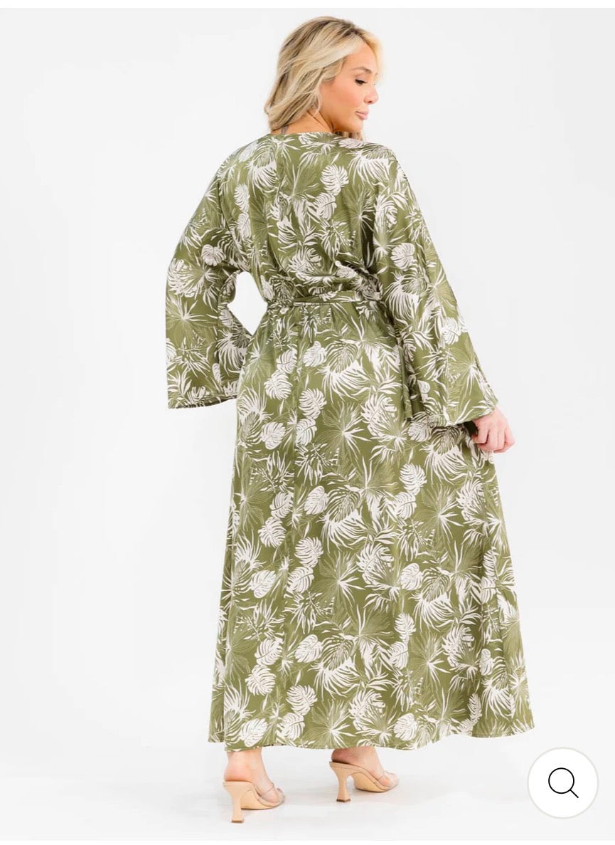 Vestido verde maxi plus size de manga larga con escote cruzado, lazo ajustable, abertura lateral y estampado de hojas.