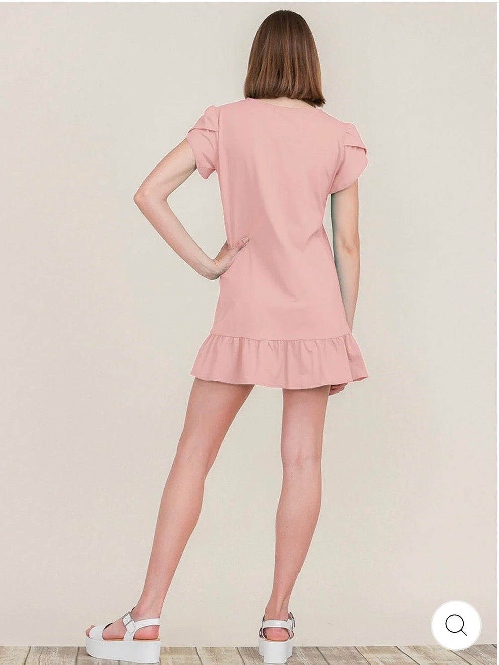 Vestido rosado corto túnica de manga corta con detalle de volante en el ruedo.