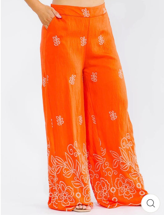 Pantalón anaranjado palazzo plus size de pierna ancha con cintura elástica, bolsillos frontales y bordado floral.