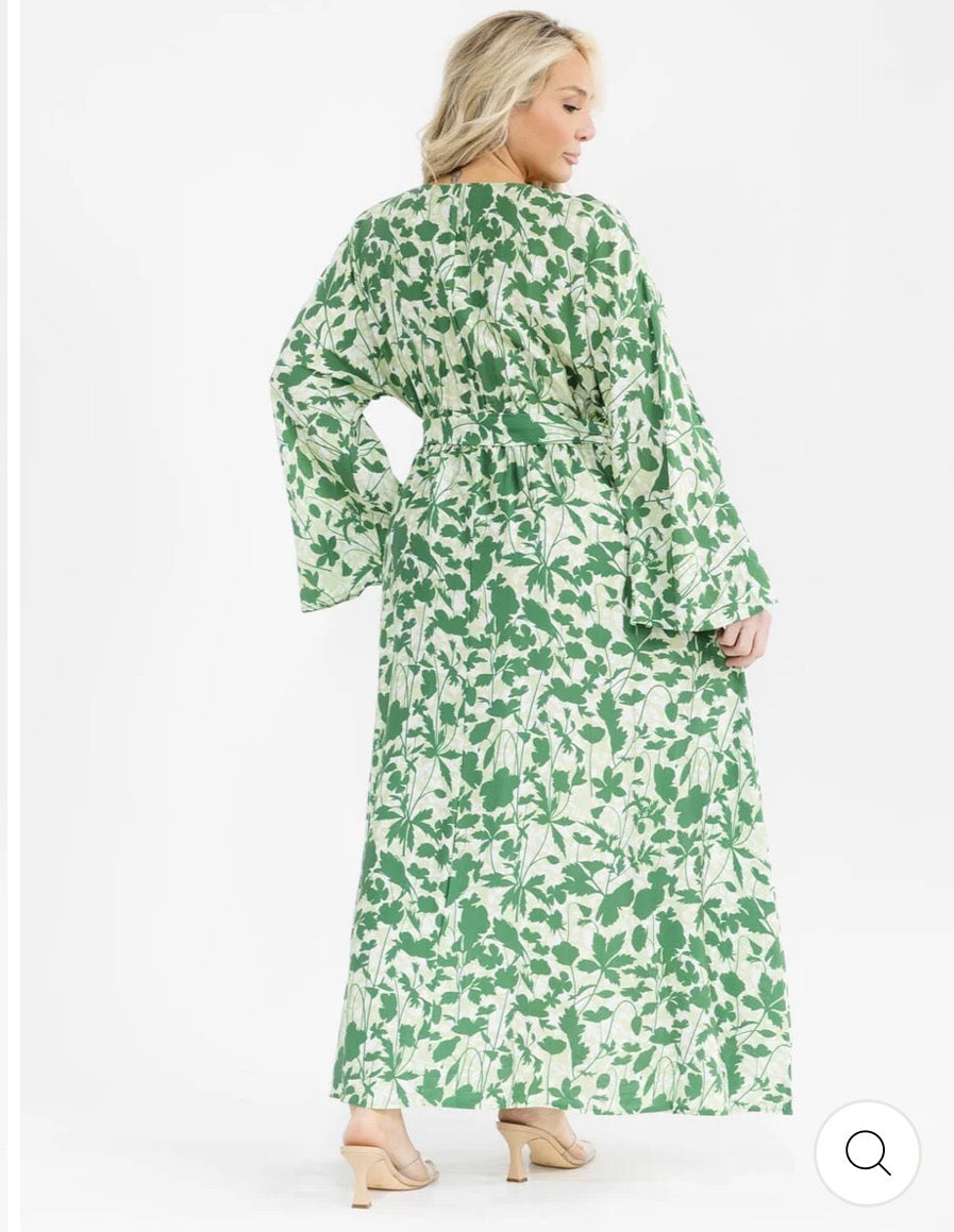 Vestido verde maxi plus size de manga larga con escote cruzado, lazo ajustable, abertura lateral y estampado de hojas.
