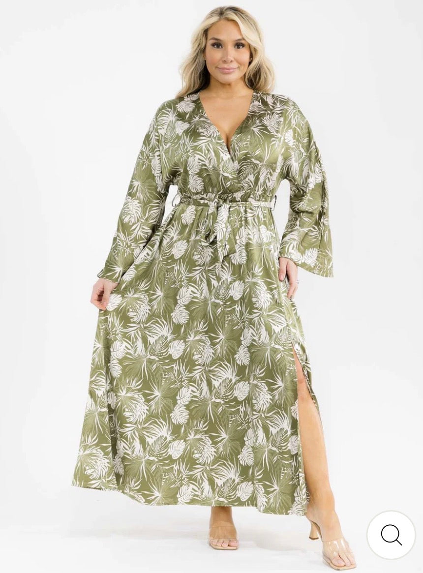 Vestido verde maxi plus size de manga larga con escote cruzado, lazo ajustable, abertura lateral y estampado de hojas.