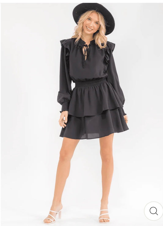 Vestido negro corto para mujer de manga larga con cintura smock, volantes en capas y silueta fit & flare.