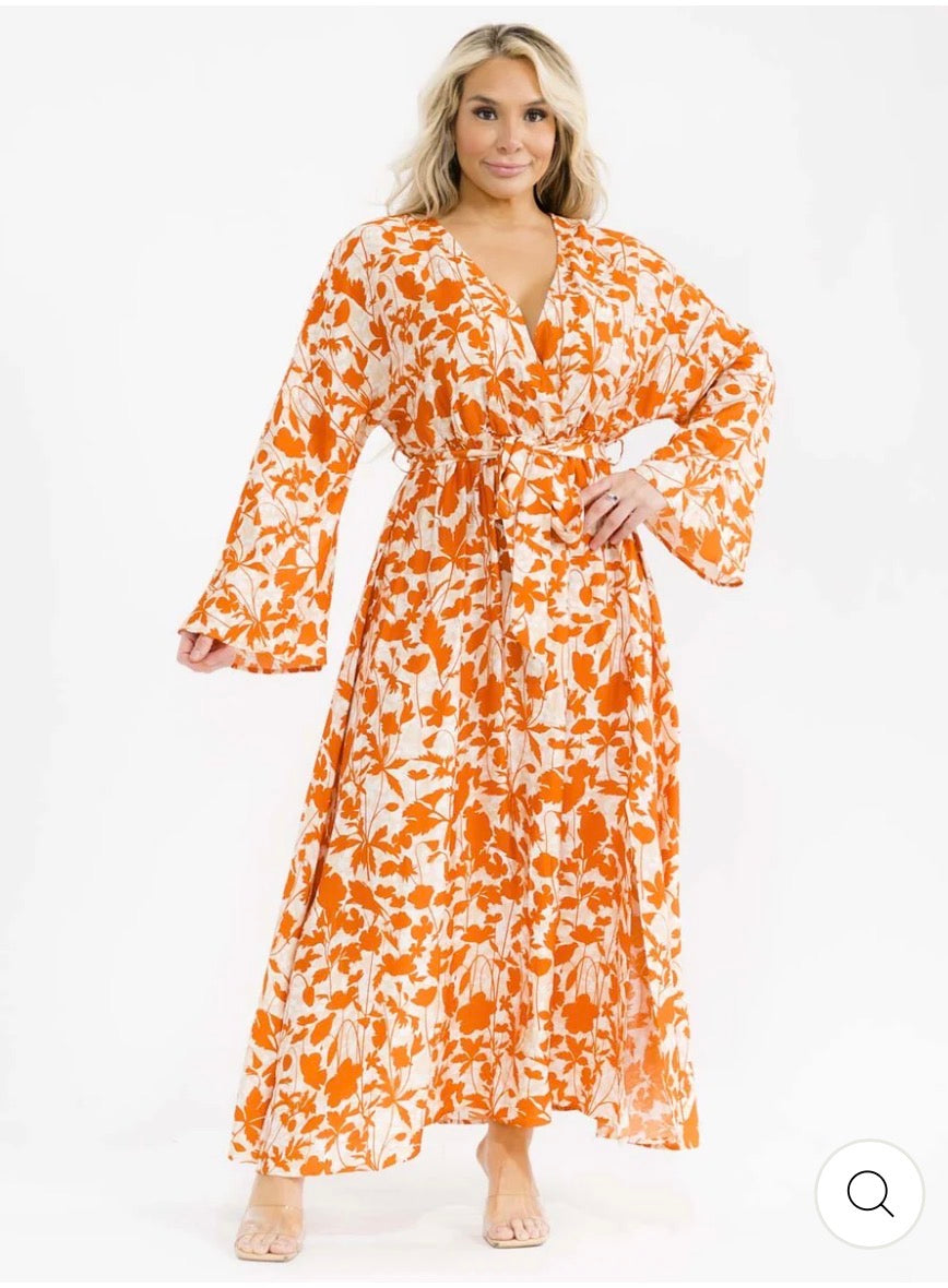 Vestido naranja maxi plus size de manga larga con escote cruzado, lazo ajustable, abertura lateral y estampado de hojas.