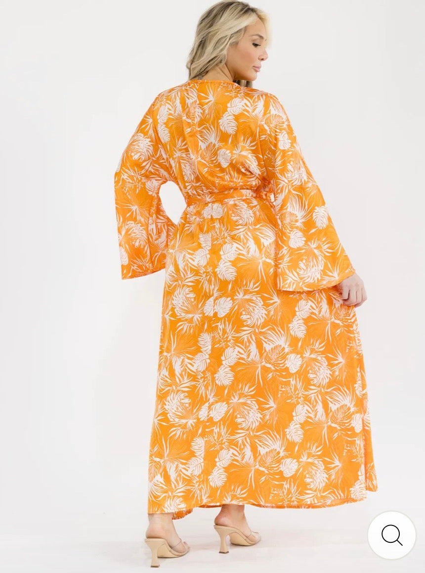 Vestido anaranjado maxi plus size de manga larga con escote cruzado, lazo ajustable, abertura lateral y estampado de hojas.