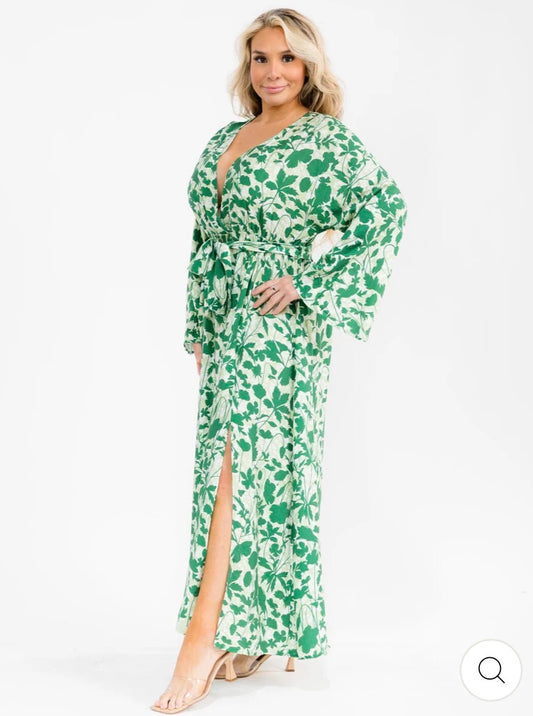Vestido verde maxi plus size de manga larga con escote cruzado, lazo ajustable, abertura lateral y estampado de hojas.