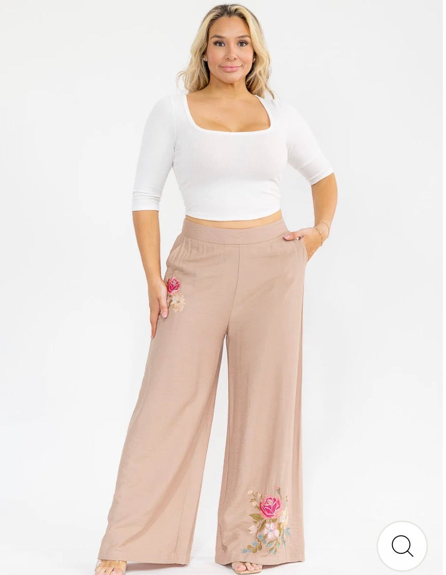Pantalón café palazzo plus size de pierna ancha con cintura elástica, bolsillos frontales y bordado floral.