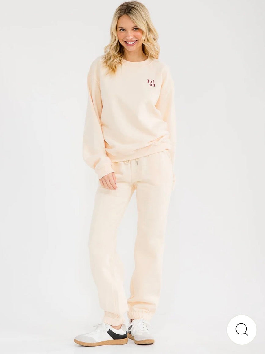 Conjunto beige de 2 piezas para mujer: suéter tipo pullover de manga larga y pantalón con cintura elástica y diseño gráfico.