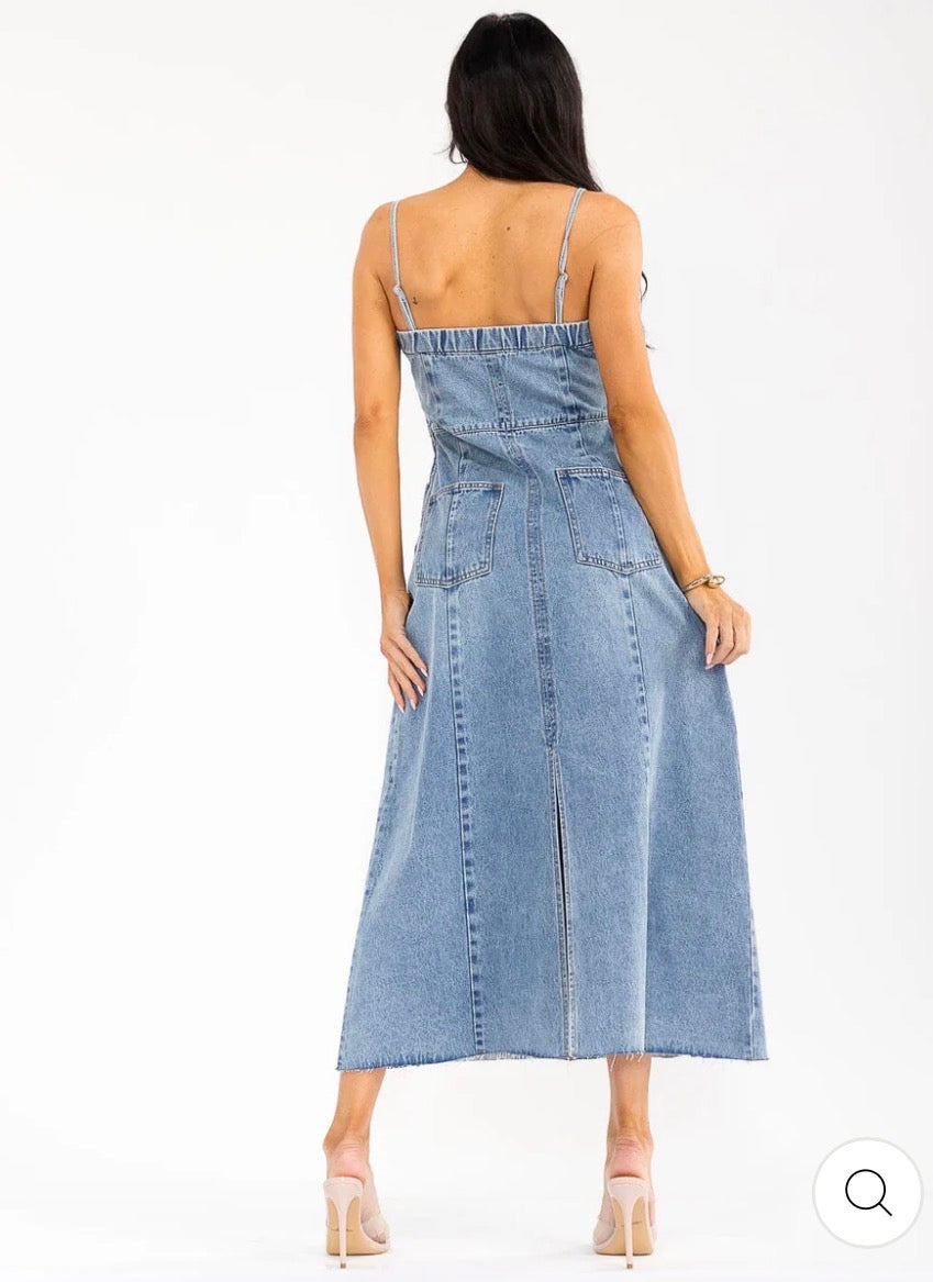 Vestido maxi azul de denim lavado para mujer, sin mangas y con bolsillos frontales.