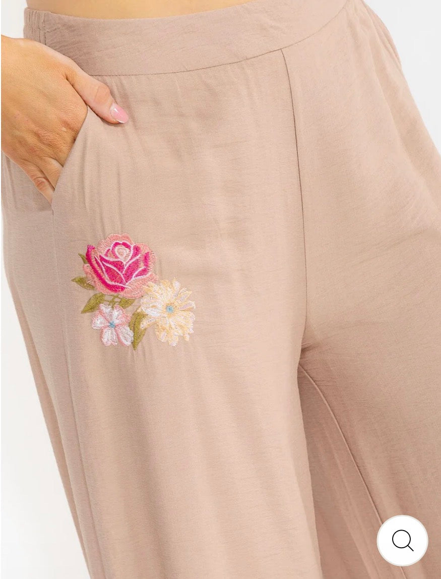 Pantalón café palazzo plus size de pierna ancha con cintura elástica, bolsillos frontales y bordado floral.