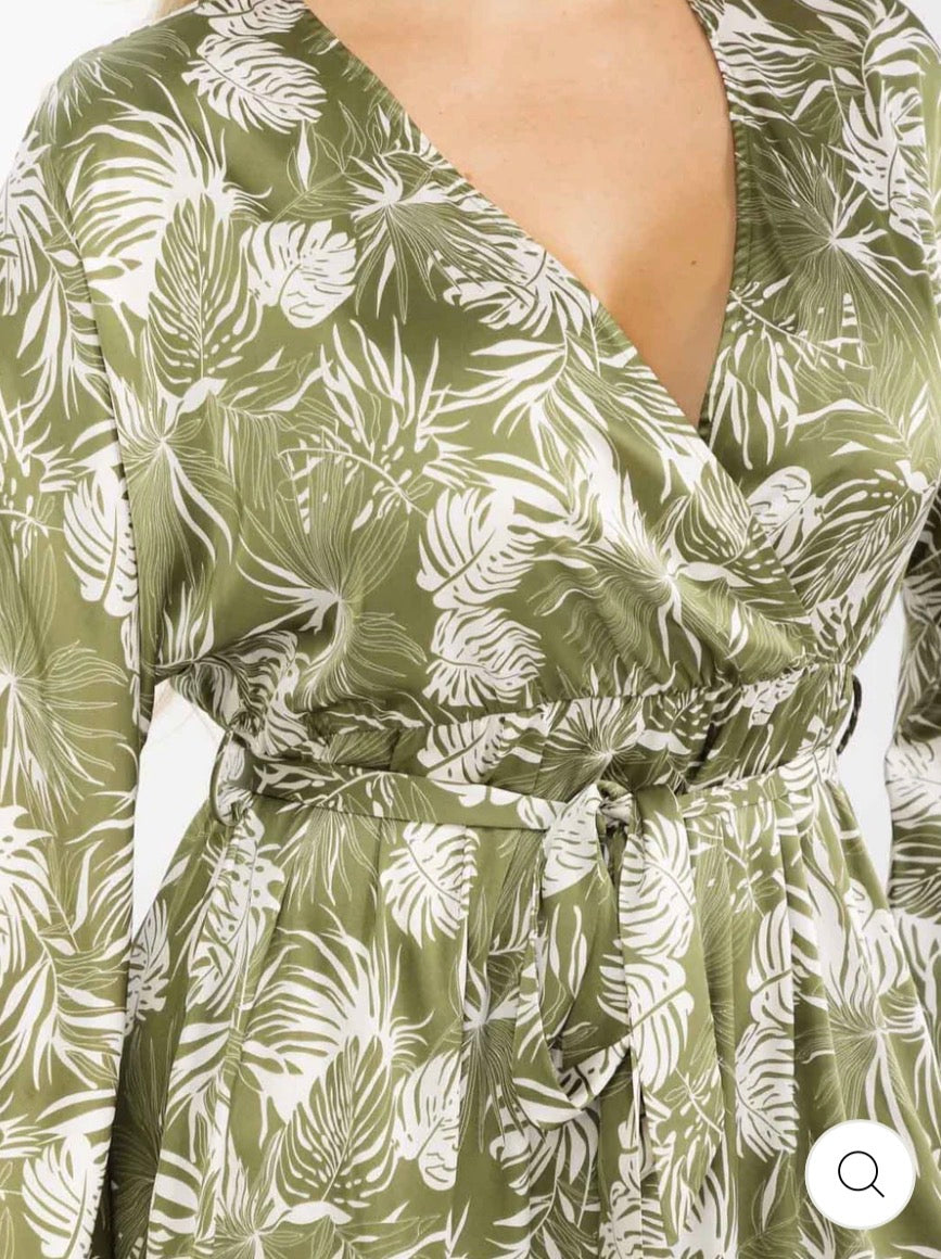 Vestido verde maxi plus size de manga larga con escote cruzado, lazo ajustable, abertura lateral y estampado de hojas.