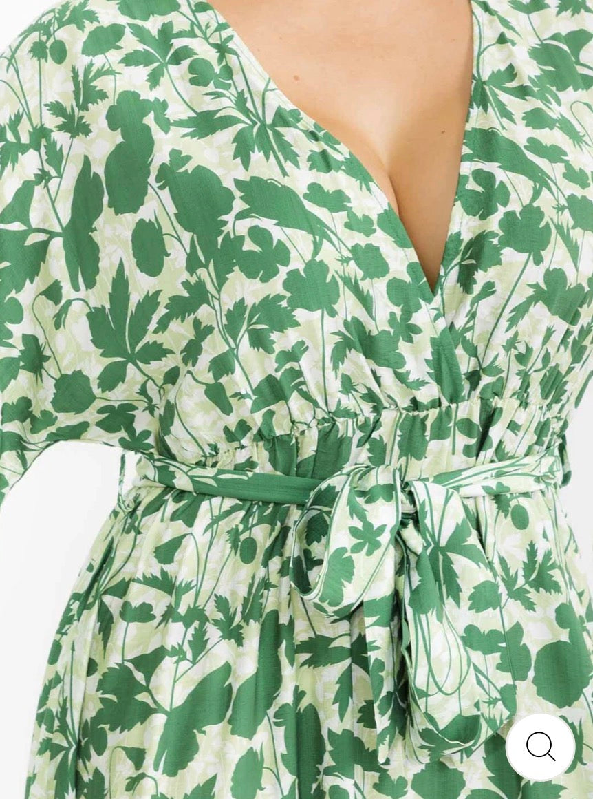 Vestido verde maxi plus size de manga larga con escote cruzado, lazo ajustable, abertura lateral y estampado de hojas.