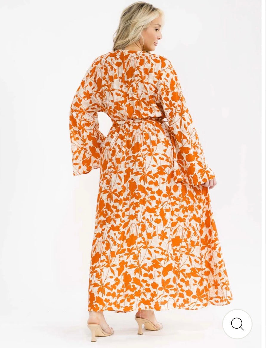 Vestido naranja maxi plus size de manga larga con escote cruzado, lazo ajustable, abertura lateral y estampado de hojas.