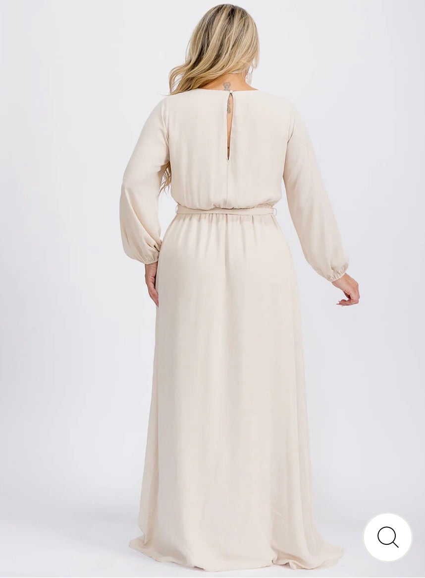 Vestido beige maxi tipo gown plus size de manga larga con escote cruzado y lazo ajustable.