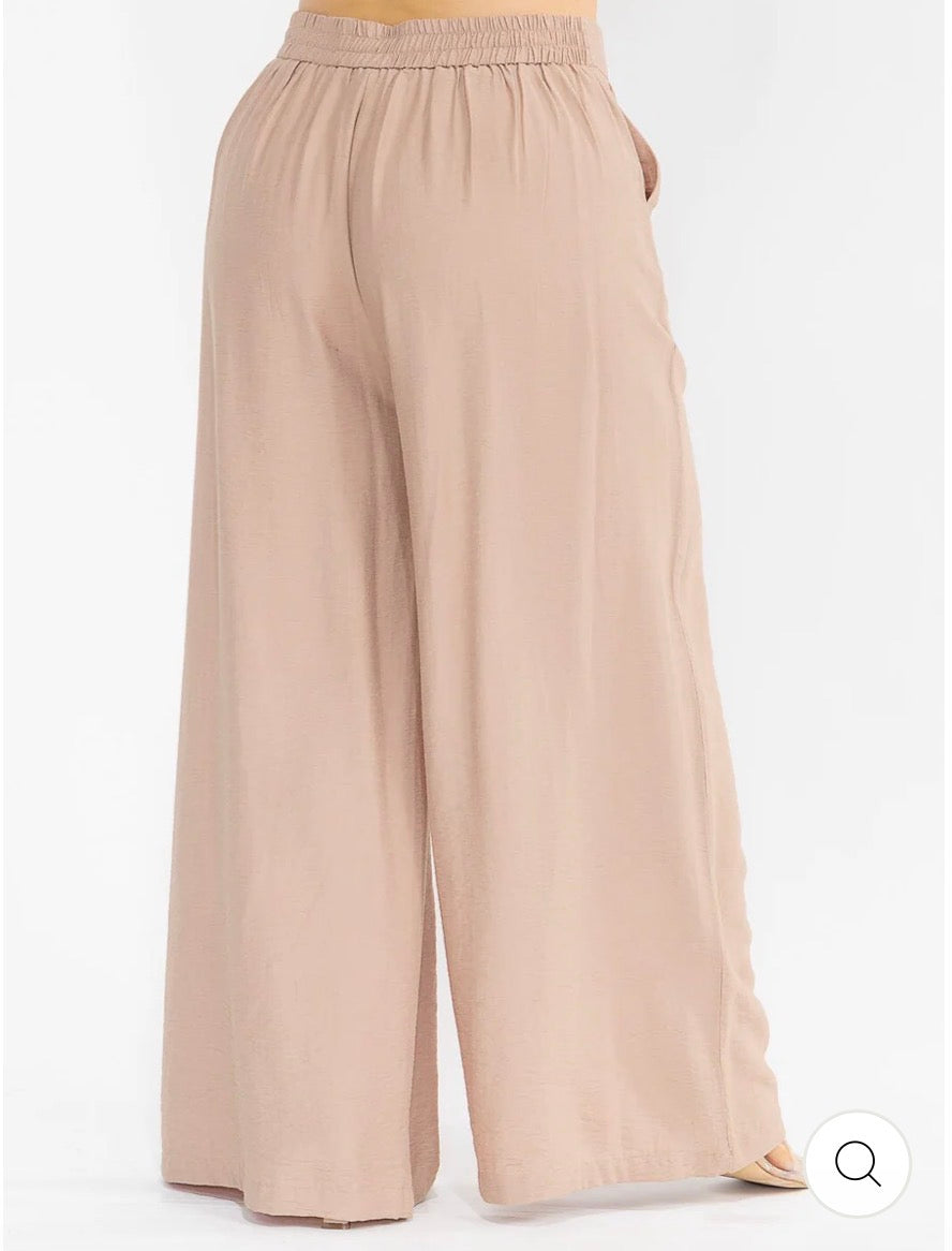 Pantalón café palazzo plus size de pierna ancha con cintura elástica, bolsillos frontales y bordado floral.