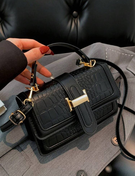 Cartera de mano color negra estilo: cuadrada y con textura