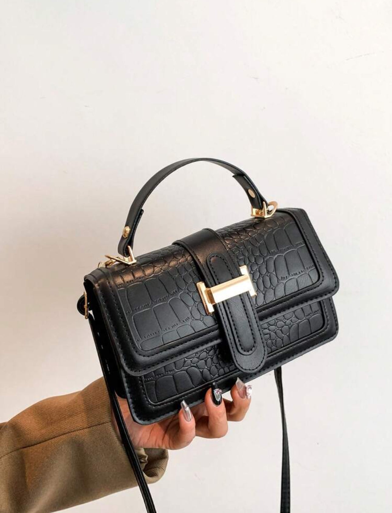 Cartera de mano color negra estilo: cuadrada y con textura