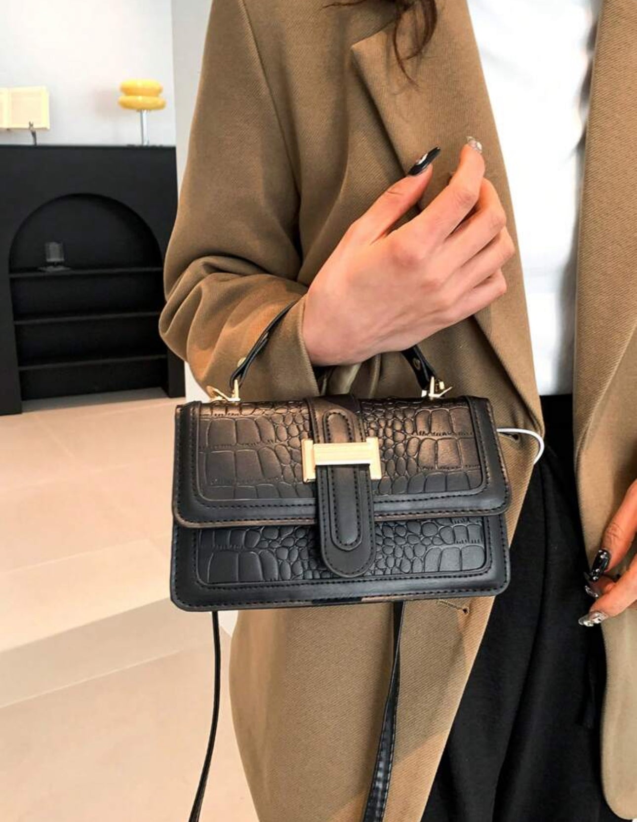 Cartera de mano color negra estilo: cuadrada y con textura