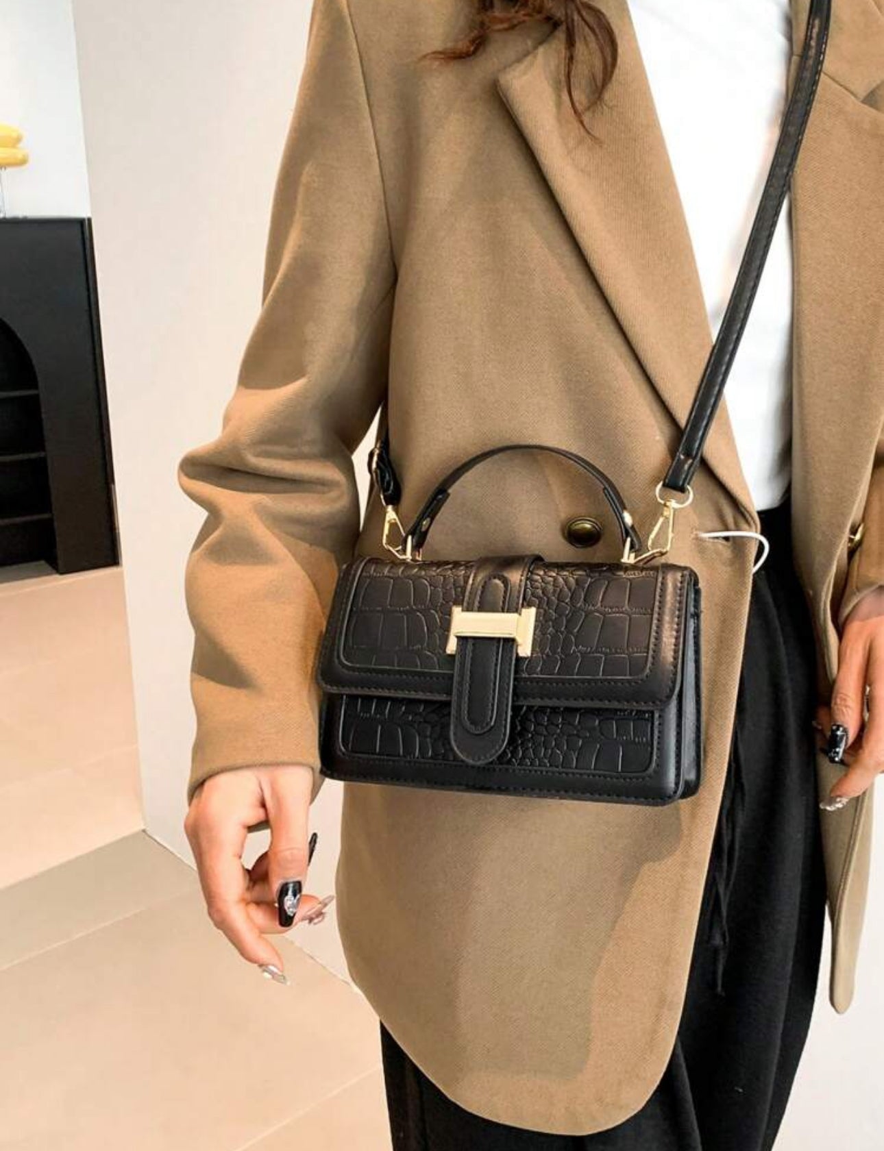 Cartera de mano color negra estilo: cuadrada y con textura