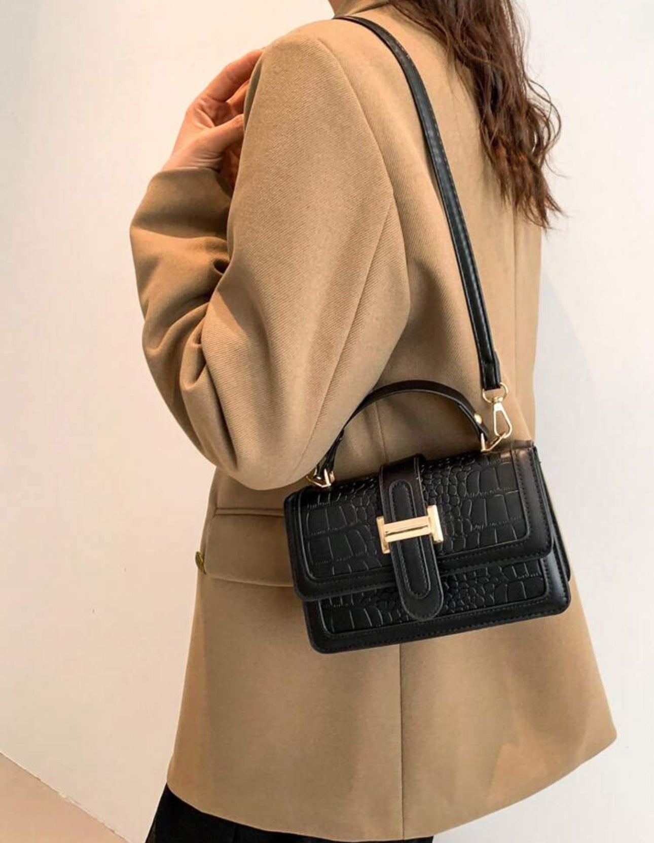 Cartera de mano color negra estilo: cuadrada y con textura