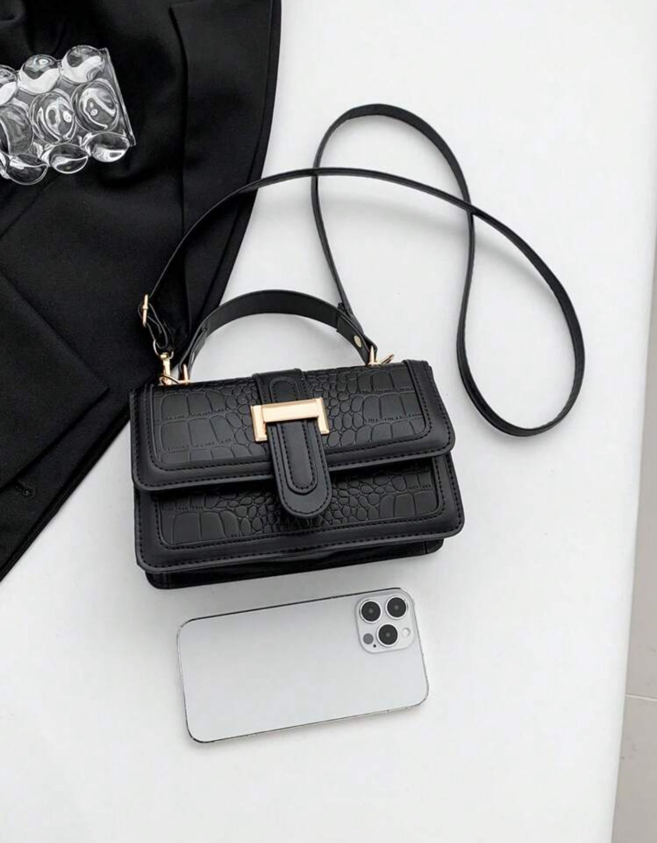 Cartera de mano color negra estilo: cuadrada y con textura