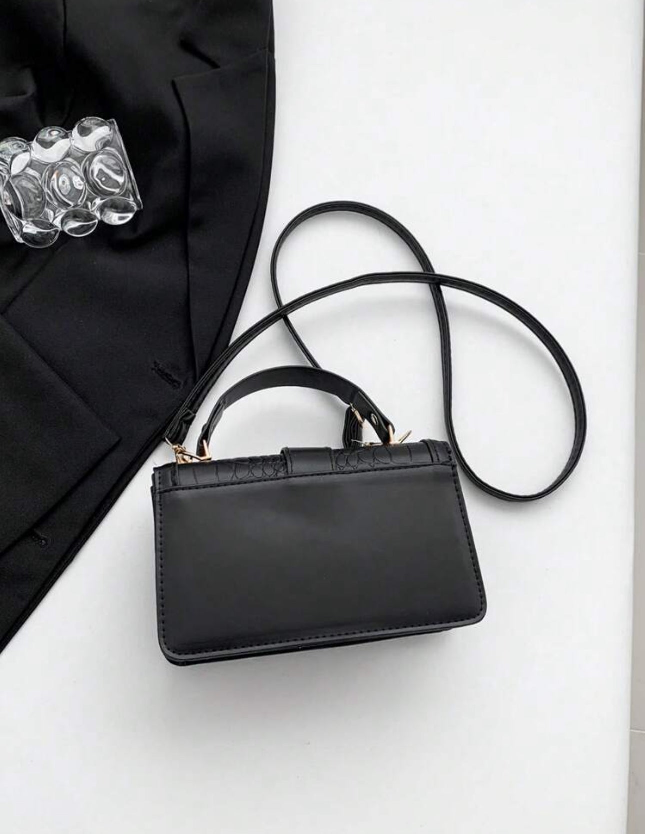 Cartera de mano color negra estilo: cuadrada y con textura