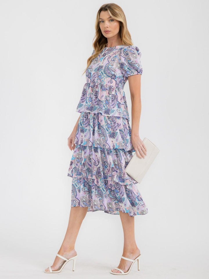 Vestido midi morado para mujer con mangas cortas abullonadas, diseño en capas (tiered) y estampado paisley.
