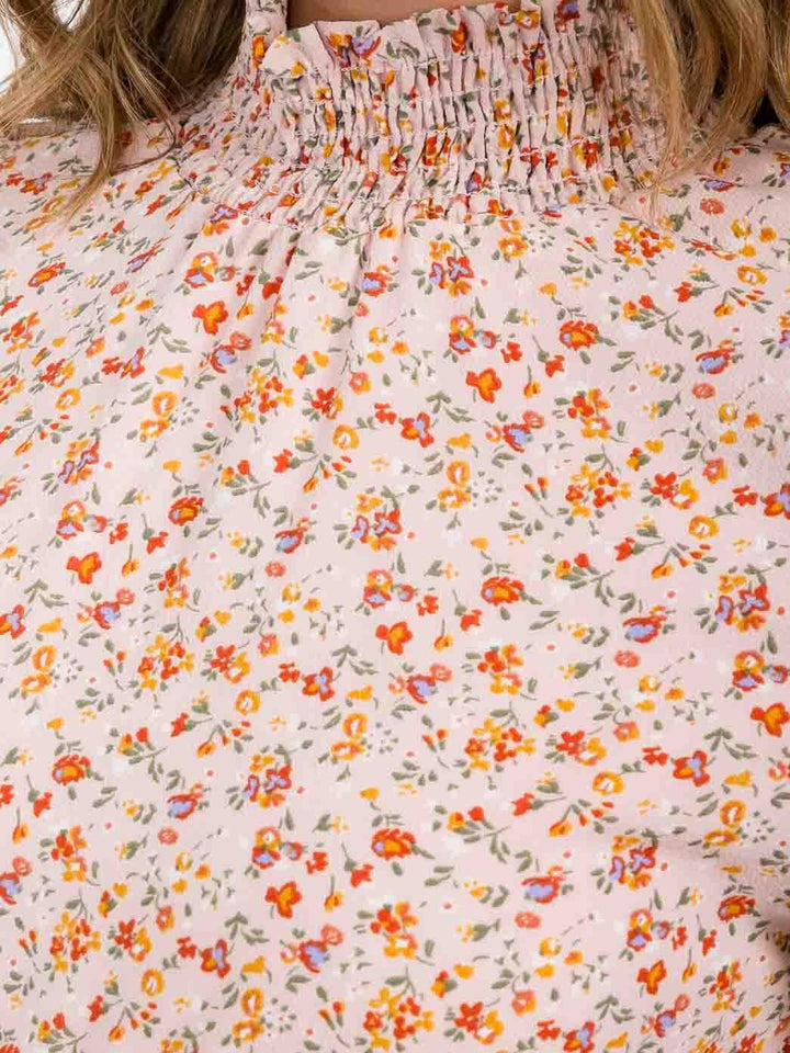 Vestido rosado corto floral para mujer con mangas 3/4, cuello alto (mock neck) y cintura elástica.