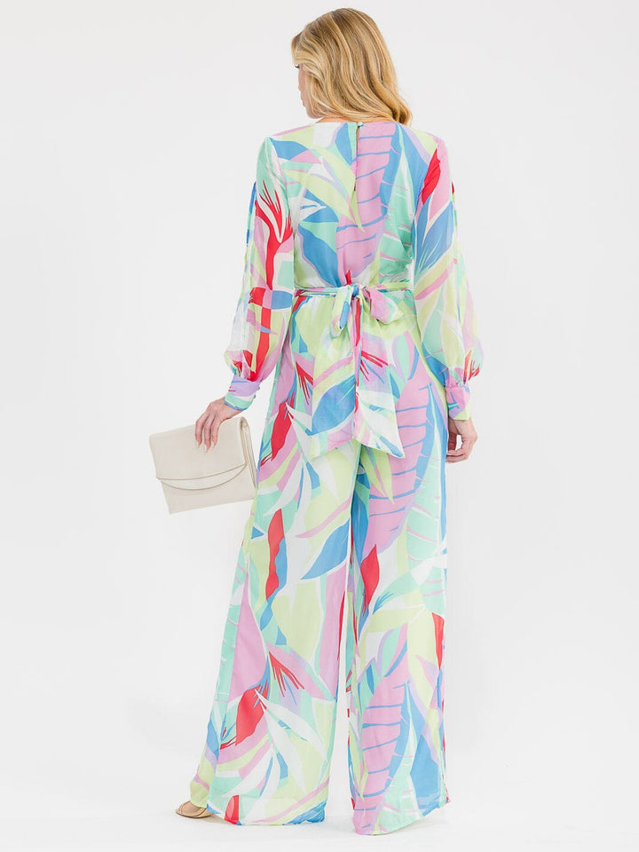 Jumpsuit pierna ancha con manga larga, escote cruzado (surplice), cintura elástica y estampado multicolor.