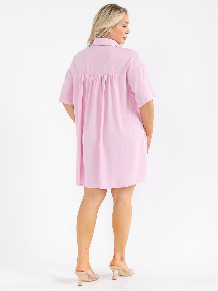 Vestido plus rosado corte holgado, con mangas cortas, botones al frente, bolsillos frontales y detalles de tachas.